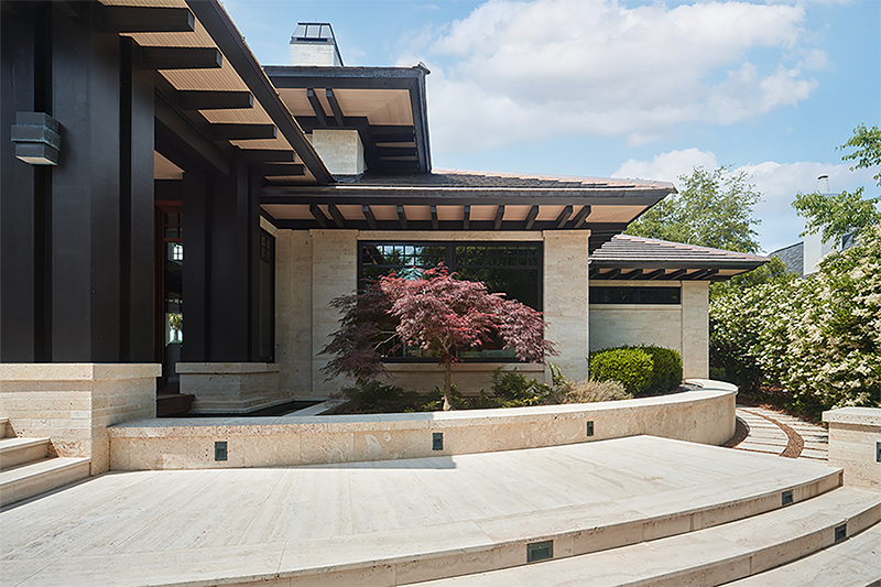 Front exterior of a desert craftsman home featuring a curved stone entry and architectural home design with natural materials and clean lines