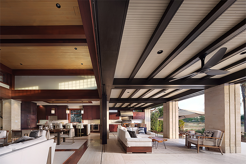 Open concept living room and kitchen blending seamlessly with outdoor space in a desert craftsman home, showcasing intentional architectural home design