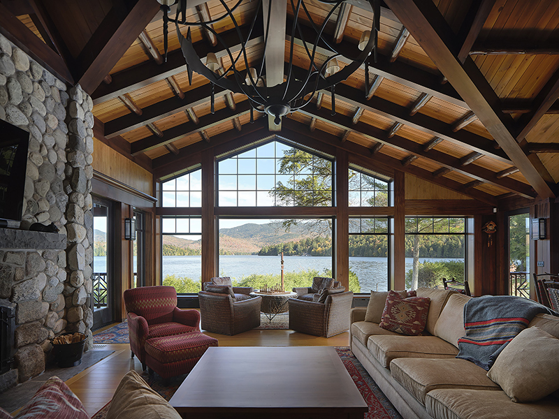 Strategic window placement in custom home reveals sweeping lake views and showcases natural light in a vaulted timber-frame great room.
