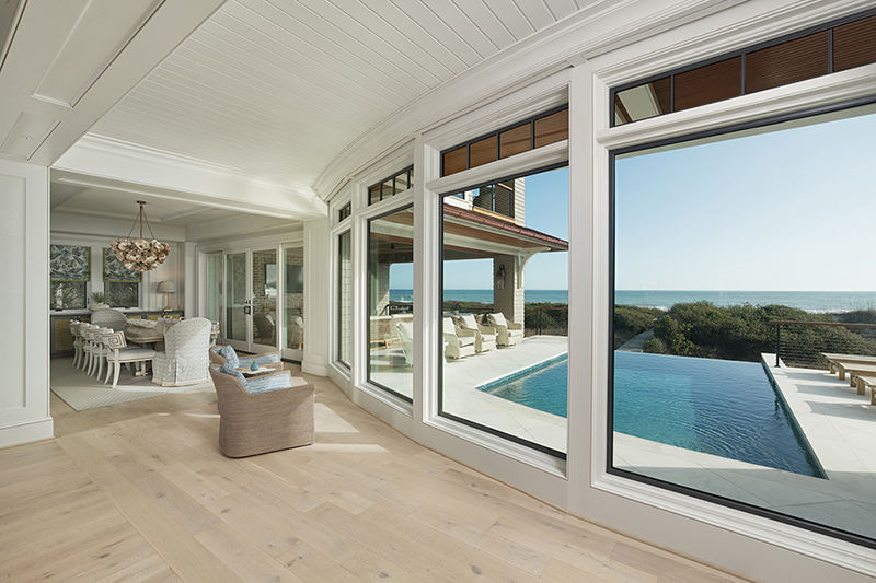 Floor-to-ceiling windows in this custom home frame ocean views, demonstrating the architecture of light and seamless indoor-outdoor living.