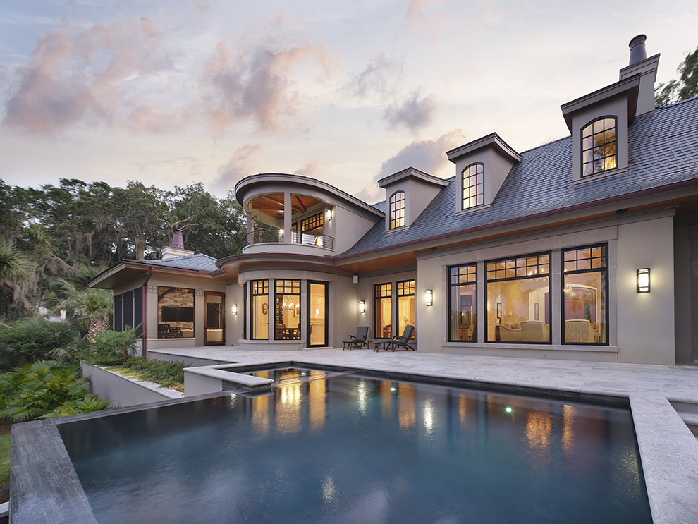 Elegant infinity pool reflecting evening light, highlighting pool design as an extension of custom residential architecture.